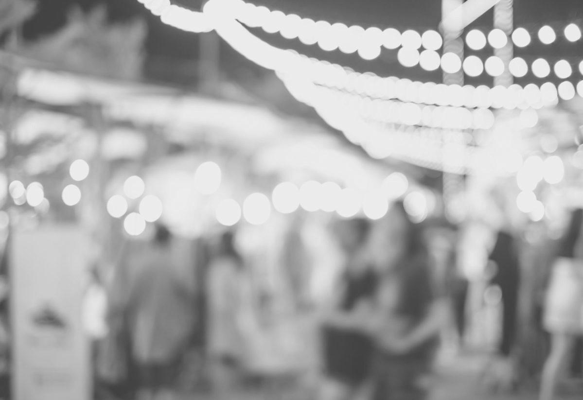 blurred image showing patio string lights and people gathered