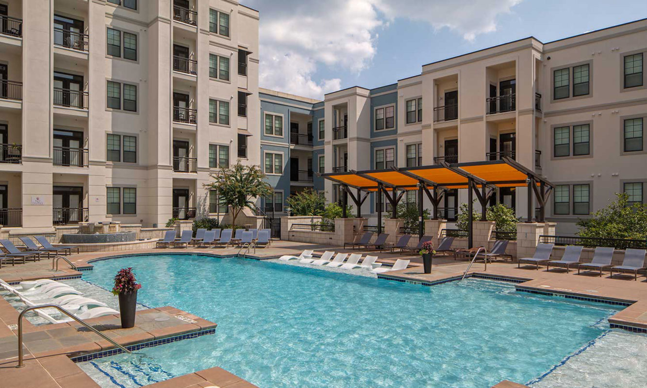 Pool with in-water lounge seats, additional lounge chairs, fountain and covered area