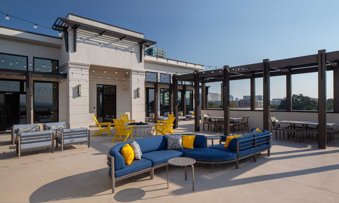 Rooftop area with patio lights, plush seating, and fire pit