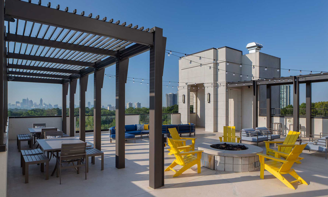 Rooftop fire pit with seating, patio lights, and additional tables and chairs