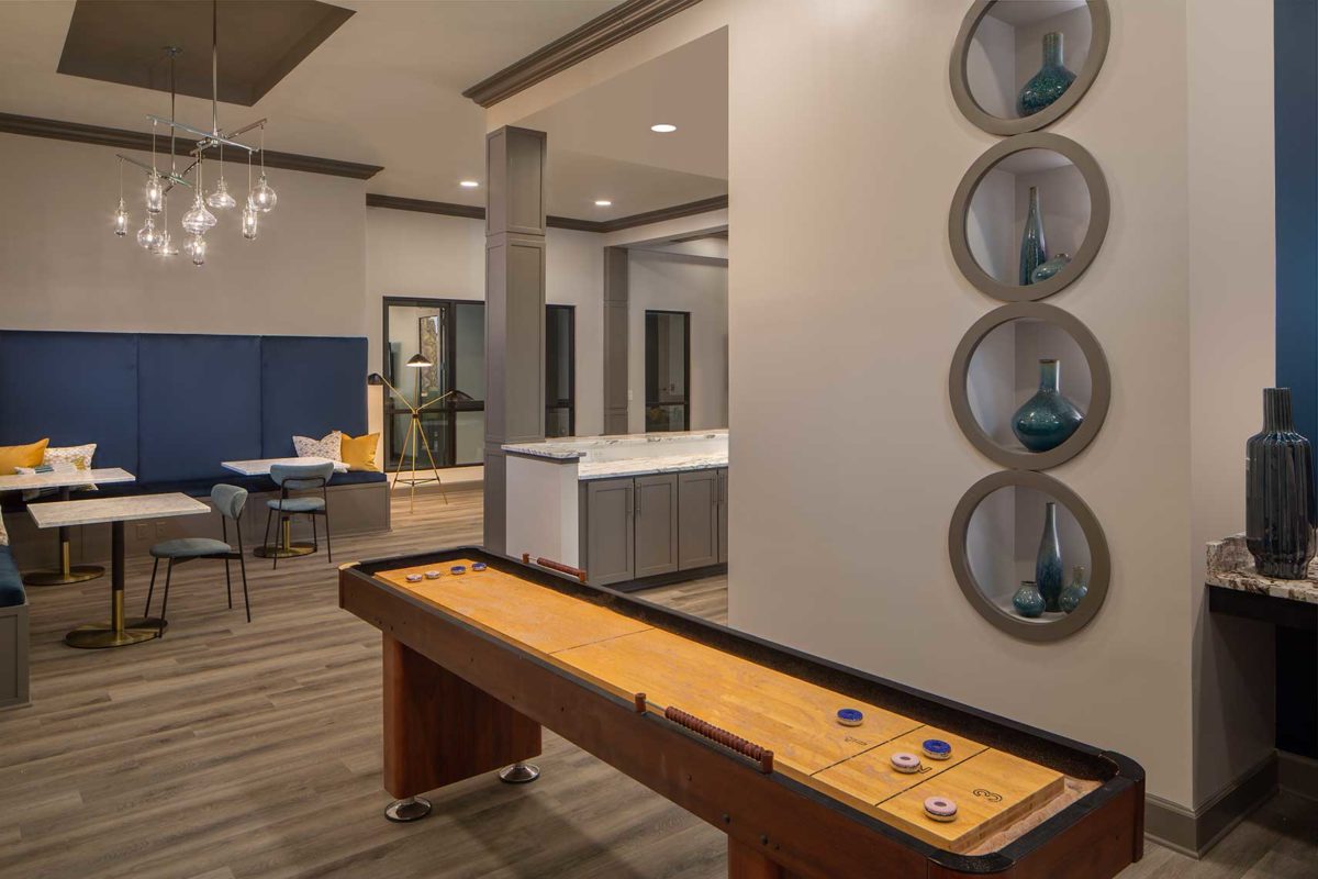 Clubhouse room with bench and chair seating and shuffleboard