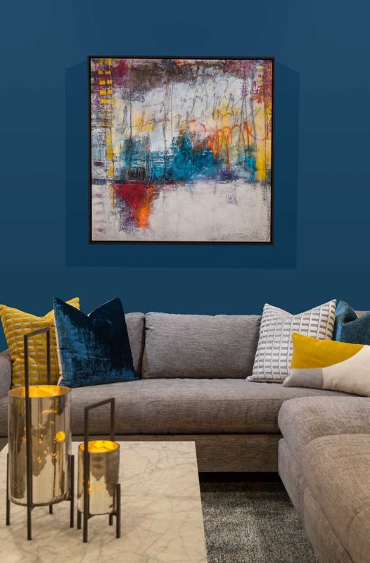 Abstract art on wall with sectional couch below